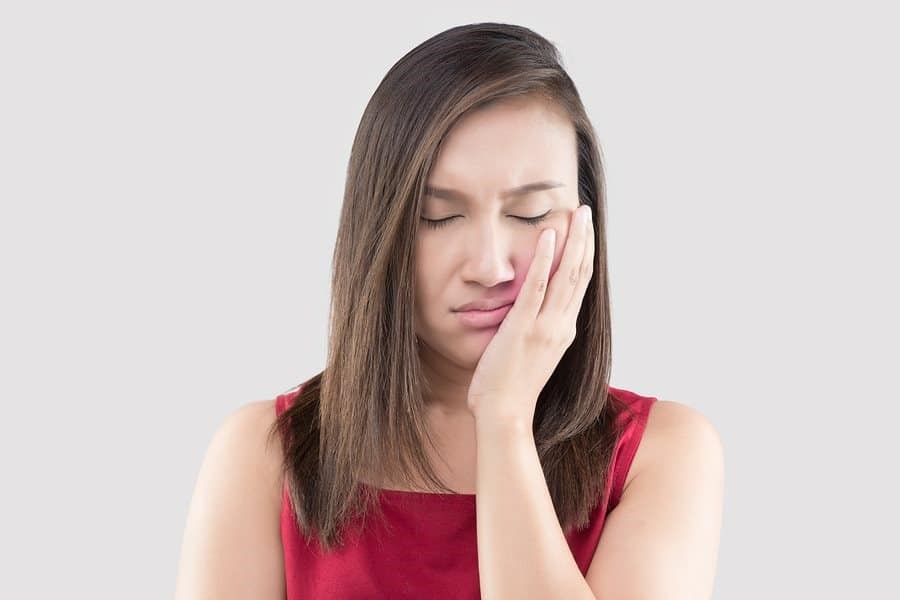 Woman holding face in pain